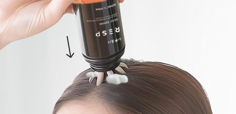 レチスパ頭皮用美容液を頭皮にスプレーする様子